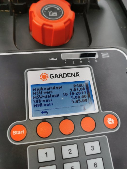 Närbild på en Gardena R40li robotgräsklipparens display som visar programvaruversioner och startknapp.