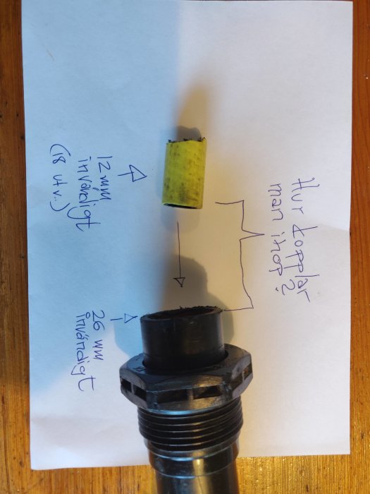 En bild på en vattenpumpanslutning med anteckningar som visar två olika slangstorlekar, 12 mm och 26 mm.