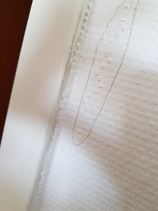 Tapet skuren längs vägglist med synliga kanter där list möter fibervägg.