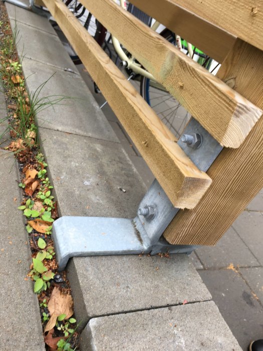 Galvaniserad stolpsko monterad på stenplattor för att stödja en trästolpe.