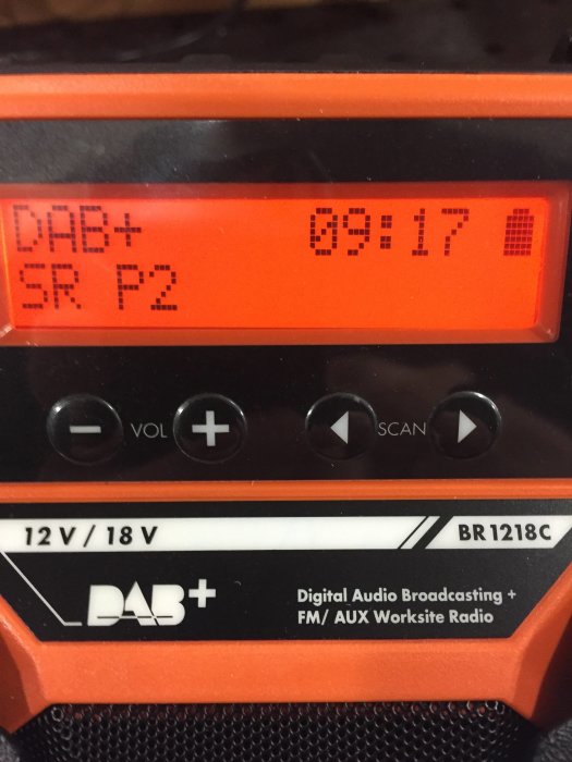 Orange DAB+/FM arbetsplatsradio visar station SR P2 och klockan 09:17 på displayen.