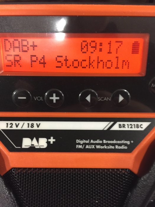 DAB-radio visar SR P4 Stockholm på displayen, tid 09:17, med orange och svarta detaljer.