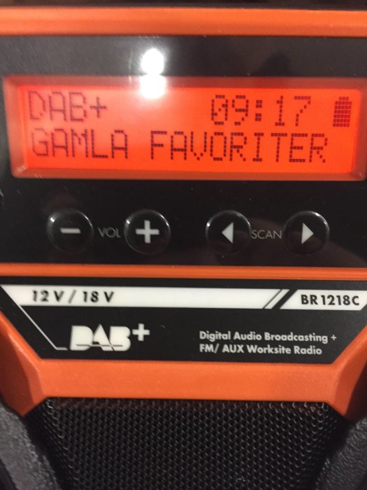 En orange och svart DAB+ byggradio som visar stationen "GAMLA FAVORITER" och klockslaget 09:17.