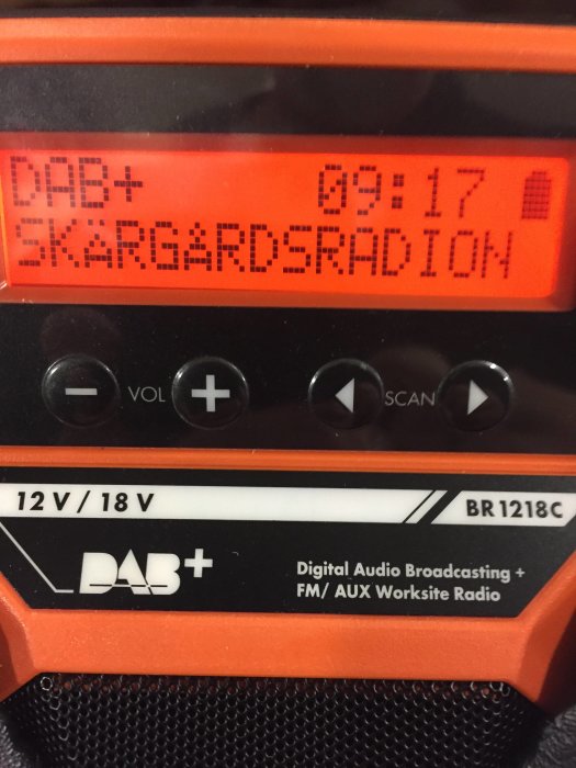 Närbild av en digital arbetsplatsradio som visar DAB-mottagning för "Skärgårdsradion" och dess funktioner.