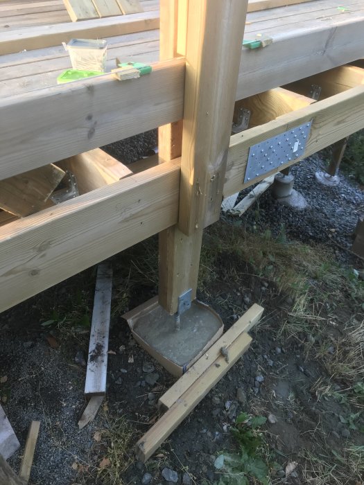 Del av ett trätrall med ett räcke som stärkts med betong och extra reglar för att minska svajning.