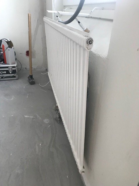 Ett vitmålat element från cirka 1968-1969 monterat på en vägg i ett rum under renovering.