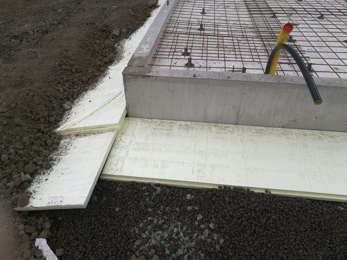 Grundisolering med cellplast vid betongplatta, jordmassor, armeringsjärn och lecakulor.