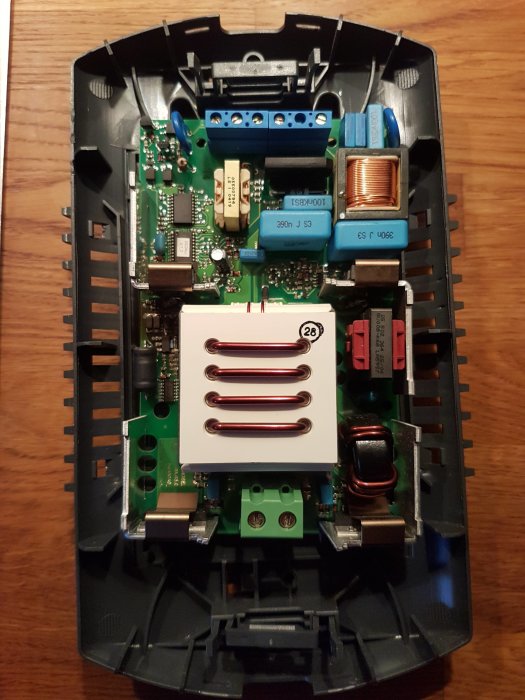 Öppen transformator med elektroniska komponenter och något brännskador, möjligen från ett köksspotsystem.