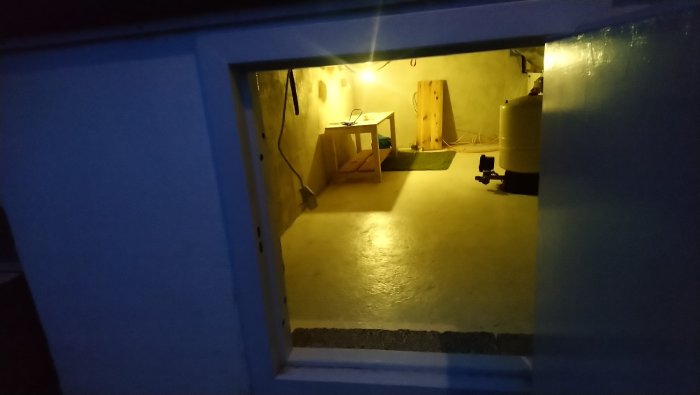Utrymme med nyligen putsade väggar och golvet, innehåller verktyg och varmvattenberedare.