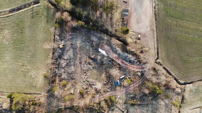 Flygbild av pågående byggprojekt med markerade vägar och en delvis grusad infart.