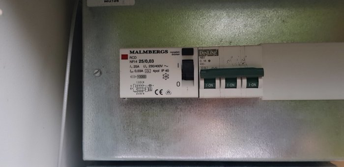 Elektrisk säkringspanel med en RCD-brytare och tre säkringar, märkta som påslagna.