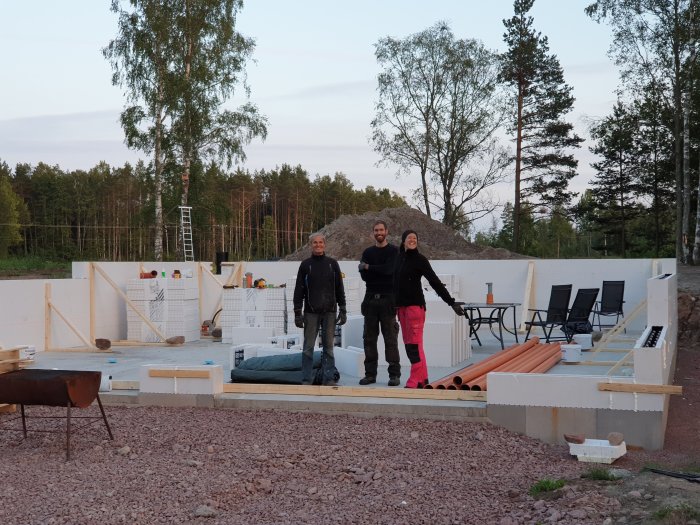 Tre personer framför påbörjad garagebyggnad med Thermomur, i ett stenigt mycket område.