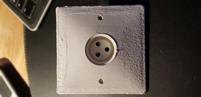 Takuttag för lampa med tre hål och ingen synlig stickpropp, monterad på en vitmålad vägg.