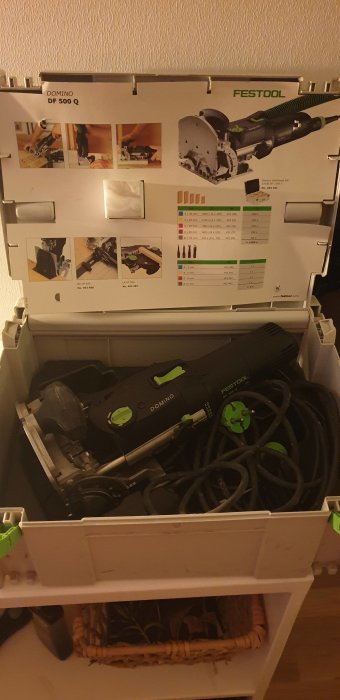 Festool Domino DF 500 Q fräsmaskin och tillbehör i en öppen låda med informationsblad.