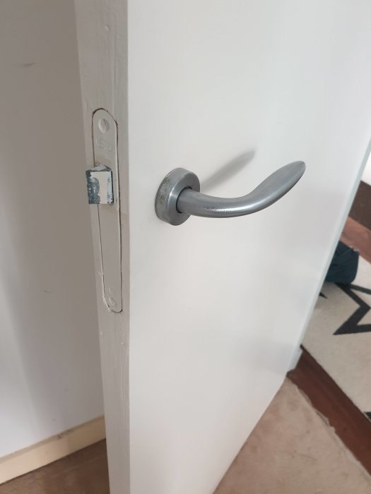 Dörrkarm och handtag utan synligt lås på en vit innerdörr.