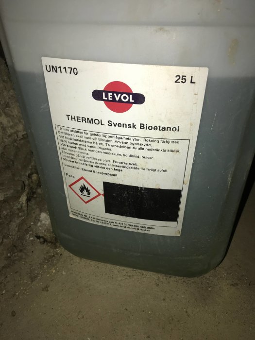 Plastdunk märkt LEVOL THERMOL Svensk Bioetanol på ett betonggolv, brandfarlighetssymbol framträdande.