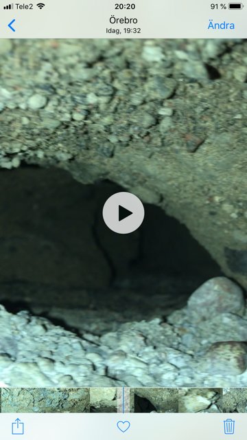 Närbild på betongrör i källaren med grus och sten runt ett mellanrum från en villa i Örebro.