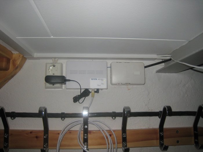 Installation av fiberutrustning under en källartrappa med synliga kablar och rör.