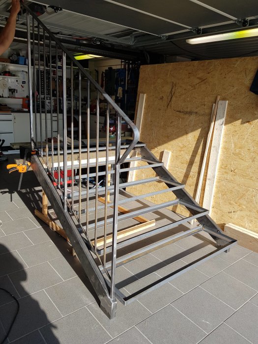 Nybyggd metalltrappa med flera steg i en välorganiserad garageworkshop.