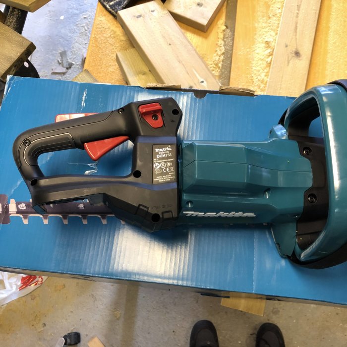 Makita DUH751Z häcksax på blå bakgrund, nyinköpt och provad på låg häck med späda kvistar.