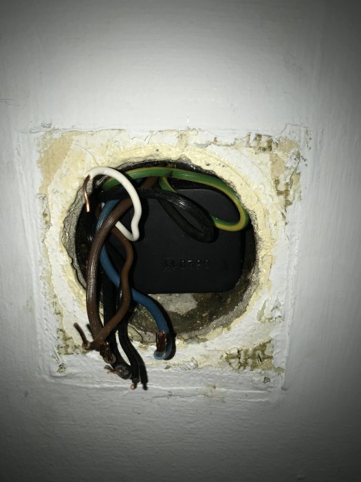 Öppet vägguttag med synliga elektriska kablar och dosa, redo för installation av dimmer.