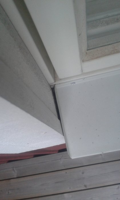 Närkarm på en byggnad som visar en spricka mellan fönsterbläck och fönsterfoder, potentiell risk för regnvatteninträngning.
