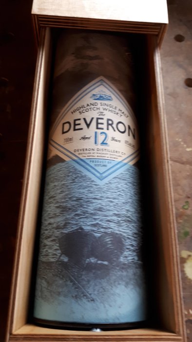 Flaska av The Deveron 12-årig Scotch Whisky i en trälåda med gångjärnslock.