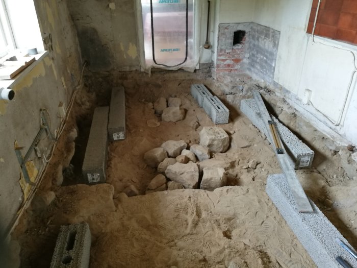Renovering av skånelänga med urgrävd mark och placerade Lecablock, markduk och golvreglar synliga.