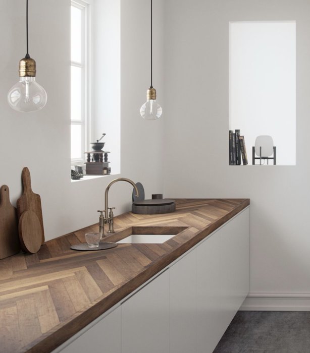 Kök med eleganta ekparkettbänkskivor och planhyvlade eklist, designbelysning och modern inredning.