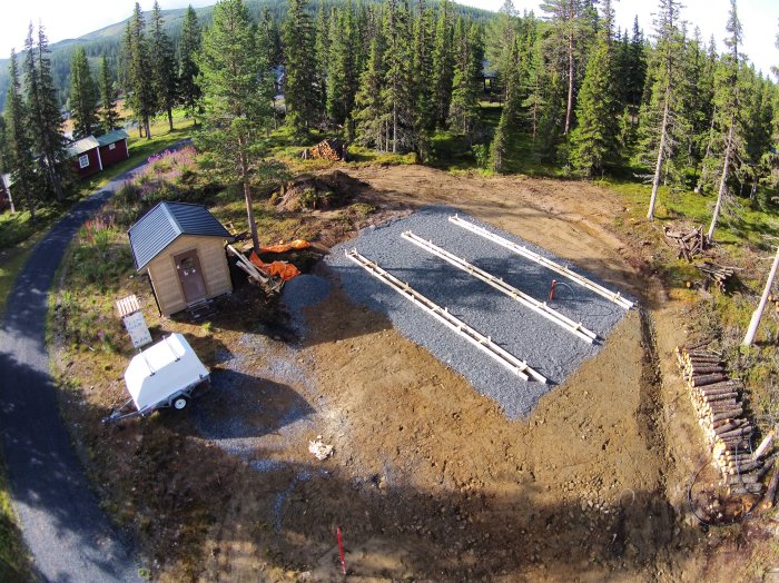 Formsatt och armerat fundament för betonggjutning på byggarbetsplats i skogsmiljö.