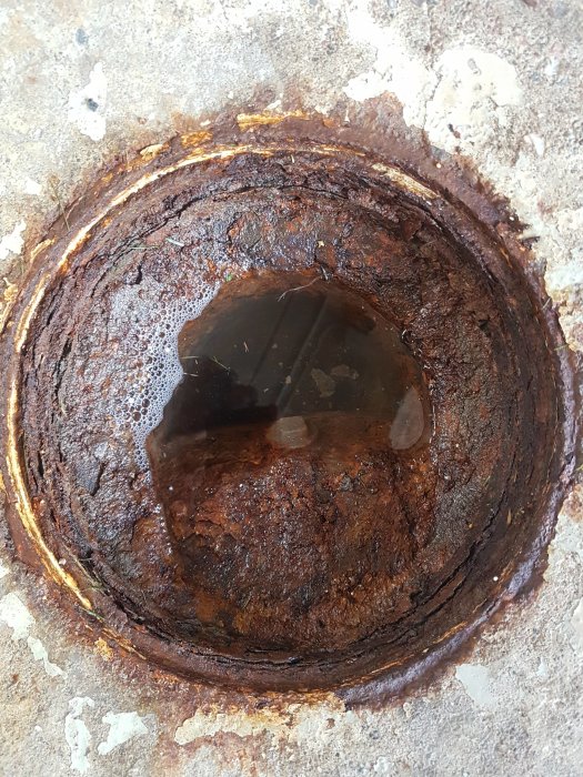 Rostigt avlopp i garage med synligt dåligt flöde och fråga om råd för rengöring.
