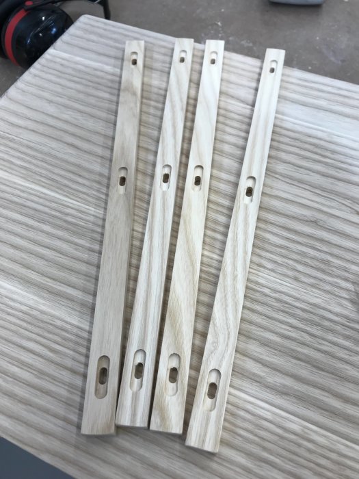 Hantverksmässigt tillverkade träglidlister placerade på ljust träunderlag.