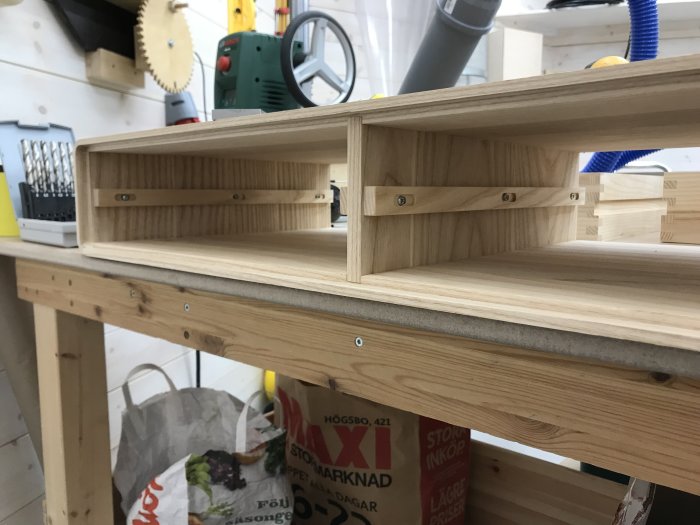 Hemgjorda trä lådor med glidlister, inne i en verkstad, innan ytbehandling och montering av botten och front.