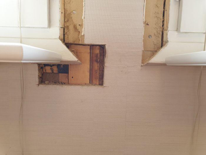 Inspektionshål i vägg med synliga reglar mellan fönsterkarmar, redo för balkmontering.