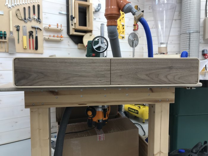 Träpanel perfekt inpassad i arbetsbänk i snickarverkstad, verktyg i bakgrunden.