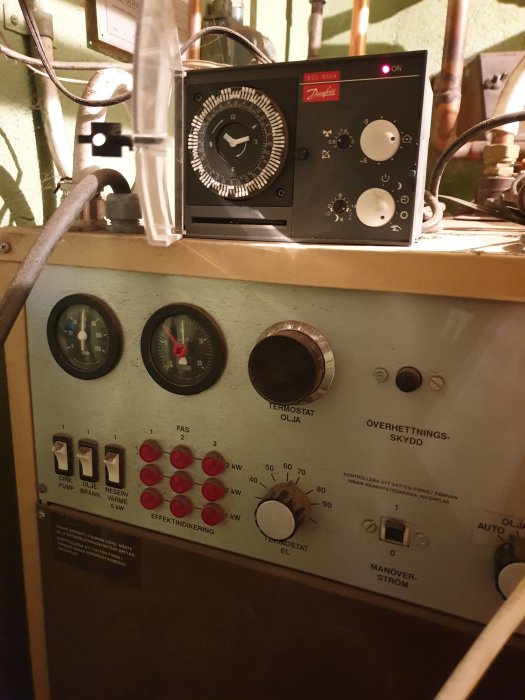 Kontrollpanel för pannsystem med termostater, reglage och indikatorlampor, undran om vilket reglage som ska justeras.