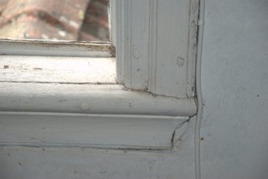 Gammelt hvitt trevindu med slitte karmer fra et hus bygget rundt 1780.