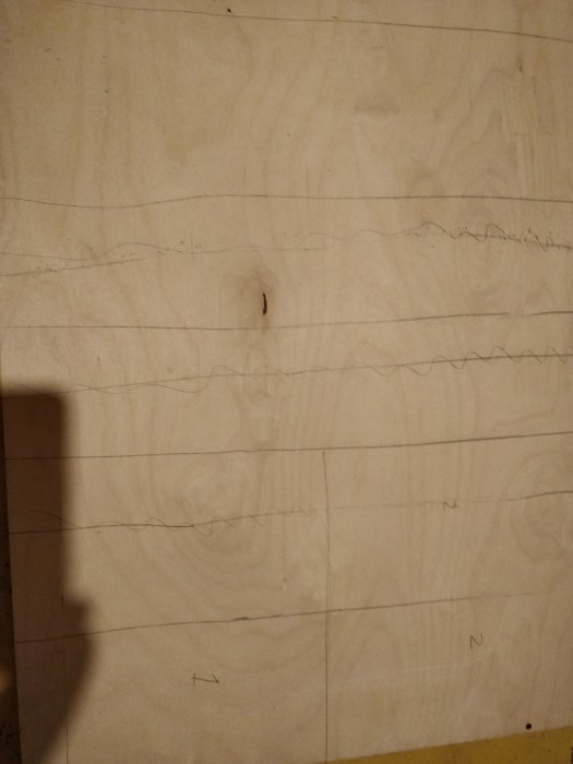 Björkplywood med uppritade linjer och markerade sektioner för planering av en boxjointjigg.