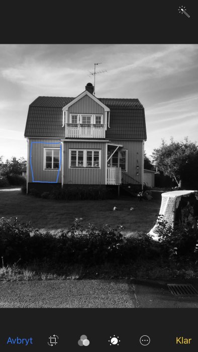 Svartvit bild på en tvåvånings trävilla med blå markering där tillbyggnad planeras.