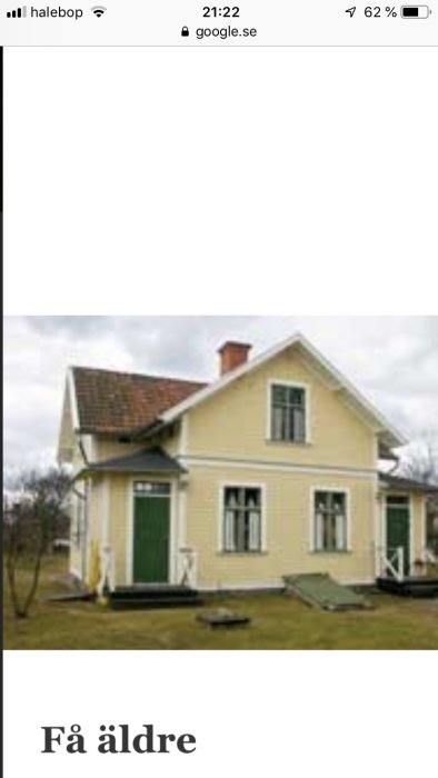 Ljust gulmålat hus med valmat tak och ett mindre tak i vinkeln mellan två huskroppar.