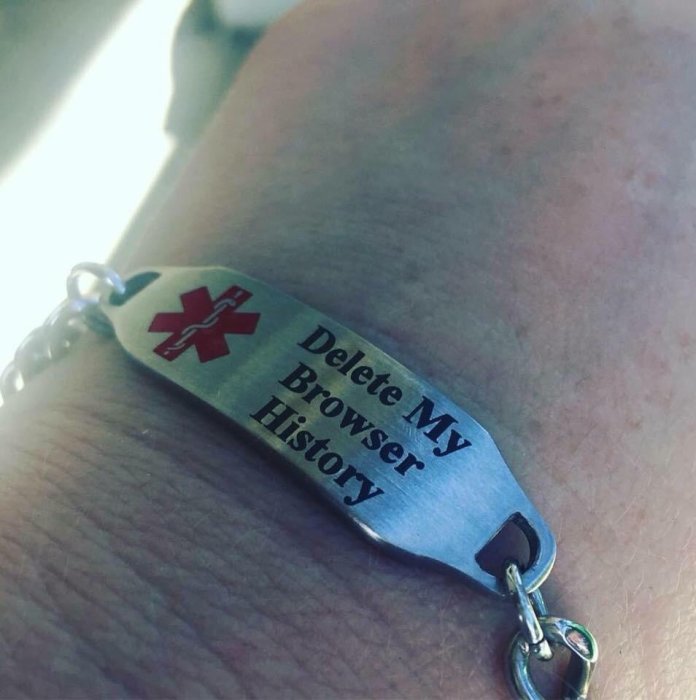 Armband på ett handled med text "Delete My Browser History" och ett rött kors.