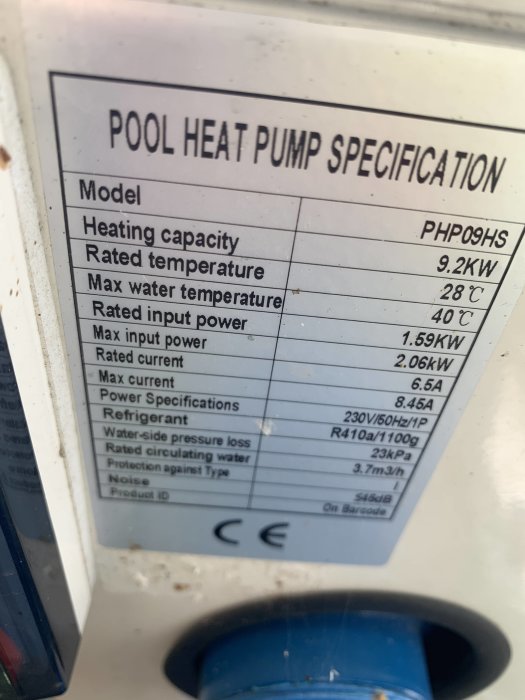 Närbild av en etikett på en poolvärmepumps specifikationer som visar modell, kapacitet, och kylmediet R410A.