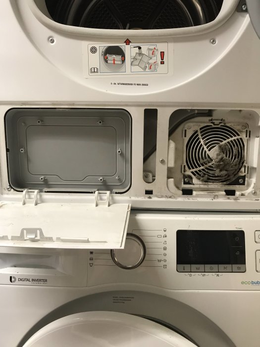 Tvättmaskin med öppet grått lock på vänster sida och instruktioner ovanför.
