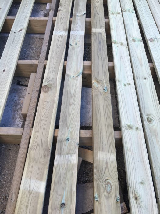 Nya trallbrädor med ljusa märken efter mellanlägg staplade ovanpå varandra.