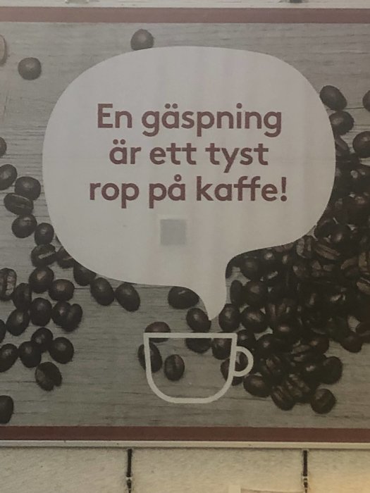 Reklamskylt med texten 'En gäspning är ett tyst rop på kaffe!' omgiven av kaffebönor och en skiss av en kaffekopp.