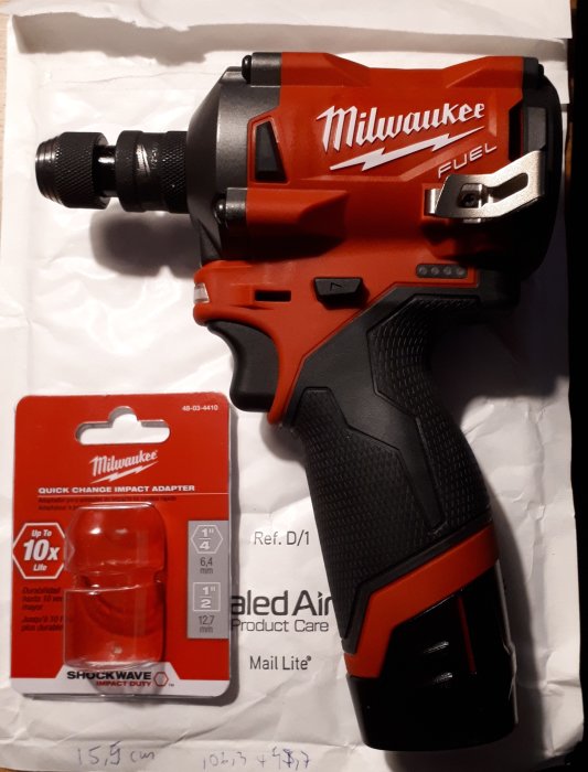 Milwaukee M12 FIWF mutterknackare med monterad skruvdragartillsats och förpackningen bredvid.