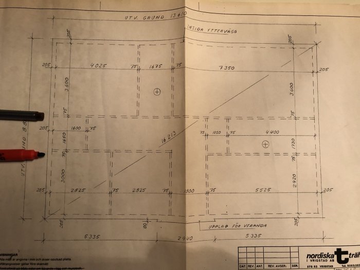 Ritning av en husplan som visar mått och layout av rum inklusive kök, vardagsrum och tvättstuga.