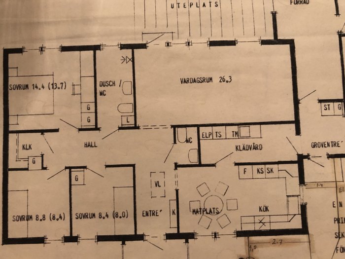 Ritning av en våningsplanslayout med markerade väggar mellan kök, vardagsrum och tvättstuga som planeras att rivas för öppen planlösning.