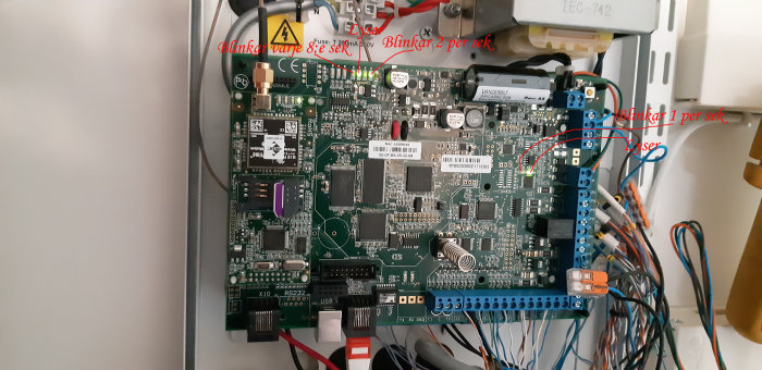 Elektroniskt centralkort med anmärkningar som visar vilka dioder som lyser eller blinkar.