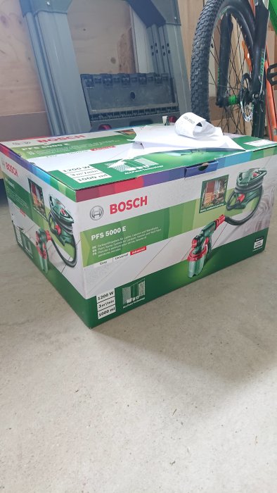 Bosch PFS 5000 E färgsprutsystem i förpackning på golvet, kvitto och papper ovanpå.